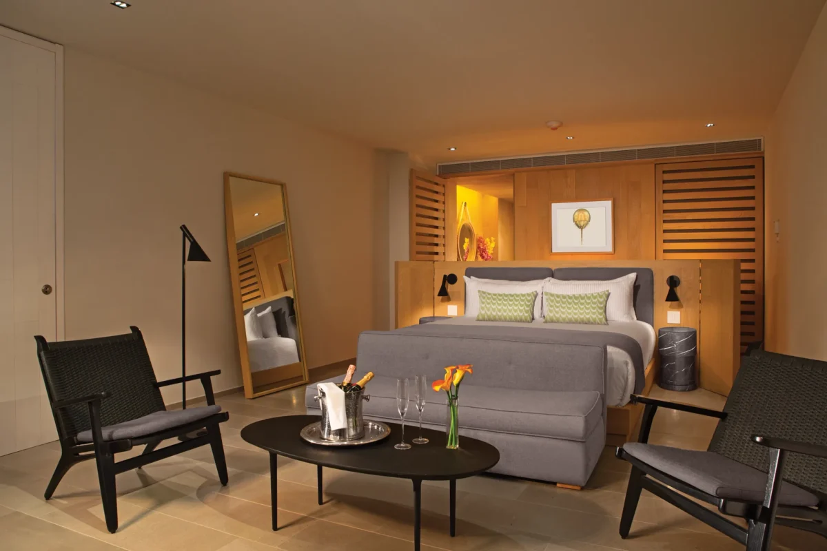 Allure Suite bedroom and living area at Breathless Cabo San Lucas with king bed, seating space, and modern décor