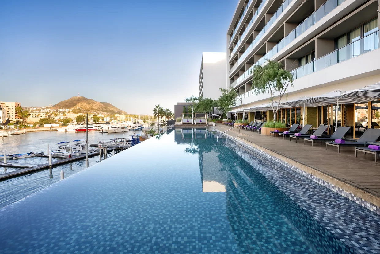 Marinafront infinity pool at Breathless Cabo San Lucas with loungers and umbrellas