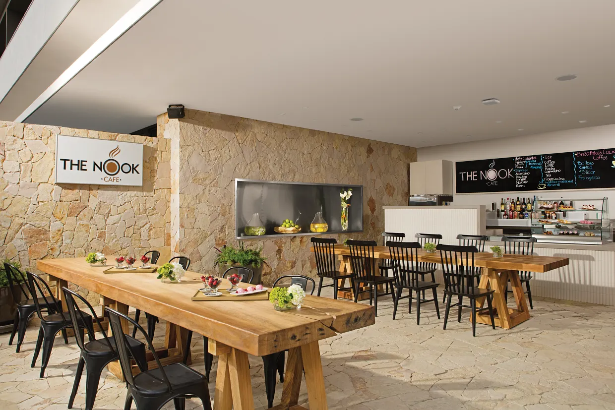 The Nook Café coffee shop interior with wooden tables and handcrafted beverages at Breathless Cabo San Lucas.