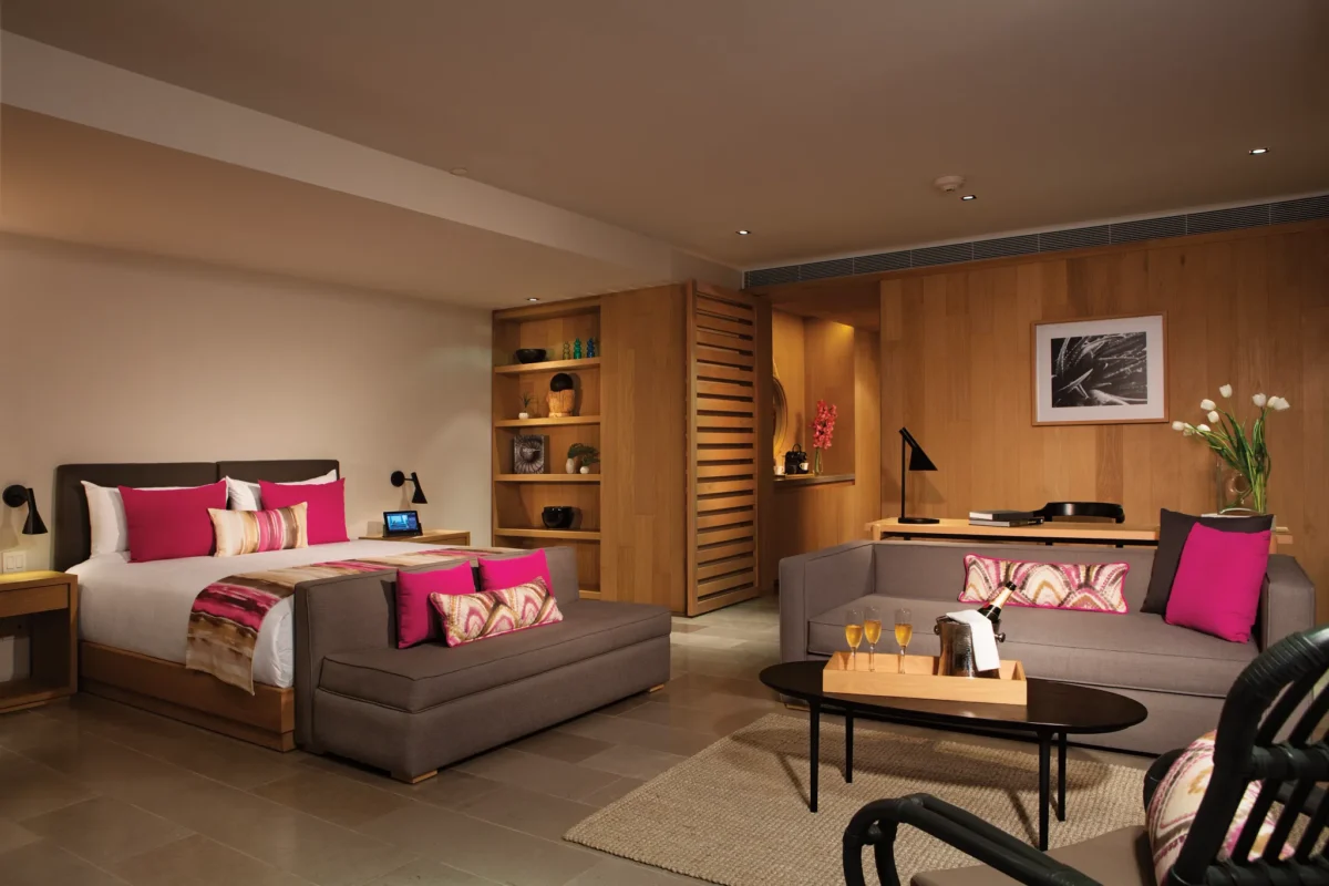 Spacious bedroom and living area of the Xhale Club Romance Suite Marina View at Breathless Cabo San Lucas with modern décor and vibrant accents.