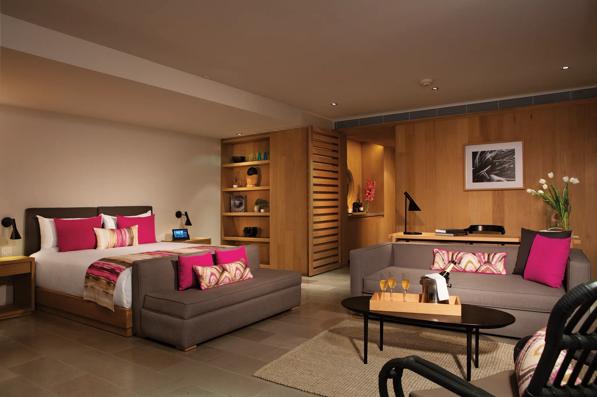 Spacious bedroom and living area of the Xhale Club Romance Suite Marina View at Breathless Cabo San Lucas with modern décor and vibrant accents.