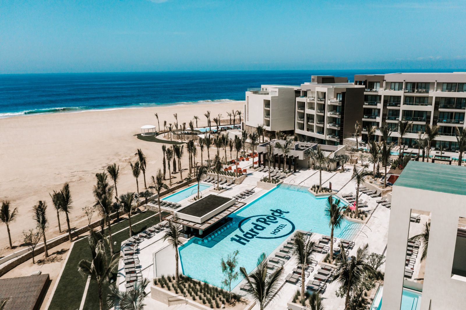 Aerial shot of Hard Rock Hotel Los Cabos with its signature branded pool and beachfront location.