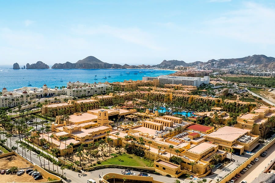 Aerial view of Riu Santa Fe resort complex with large pools and sweeping views of Cabo San Lucas Bay.
